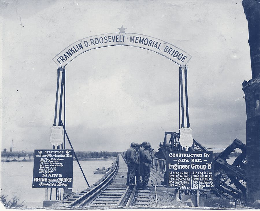 A railroad bridge entrance with an arch reading Franklin D. Roosevelt Memorial Bridge, and signboards on both sides